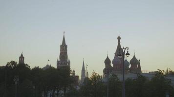 Russie, Moscou - août 15, 2021. vue de kremlin bâtiments sur horizon dans soir. action. magnifique bâtiments sur rouge carré dans Moscou. st. basilic cathédrale et spasskaya la tour sur horizon dans soir video