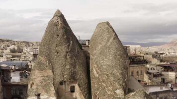 Ancient stone dwellings carved from tuff in Cappadocia, Turkey. Action. Aerial view of unusual beautiful nature, rock formations, city, and cloudy sky. video