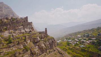 Ruins of ancient city on rocks on sunny day. Action. Stone city on rock in mountains. Historical stone town on rock above mountain valley video