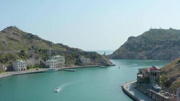 Beautiful bay with blue water and old town. Action. Top view of beautiful bay with seaside town and steep cliffs. Beautiful coast to south of Crimea video