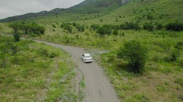 oben Aussicht von Auto Reisen im Berg Schlucht. Aktion. Reisen durch Auto auf Berg Straßen. Auto geht entlang Serpentin auf Hintergrund von Grün Berge video