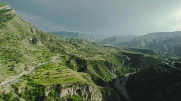 Beautiful mountain valley with rocks and lowlands. Action. Green mountain landscape with variety of terrain. Beautiful mountain landscape with rainy sky and sun video