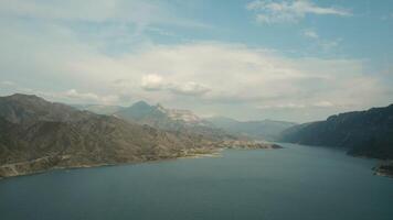 parte superior ver de grande lago en rocoso montañas. acción. hermosa azul lago en antecedentes de montaña horizonte. grande azul lago rodeado por montañas video