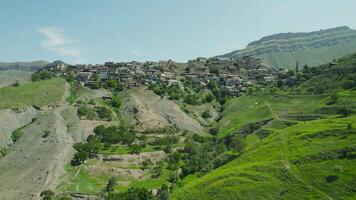 Top view of old mountain settlement. Action. Green mountain landscape with houses and settlement. Mountain settlement in Dagestan video