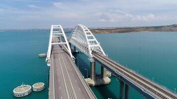 superiore Visualizza di sospensione ponte su acqua. sparo. macchine siamo guida su bianca sospensione ponte al di sopra di blu acqua. bellissimo paesaggio marino con della Crimea sospensione ponte video
