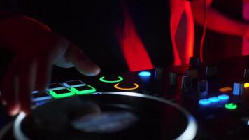 A person working on a color j-player. Clip. DJ creates music by pressing buttons and scrolling slipmat. video