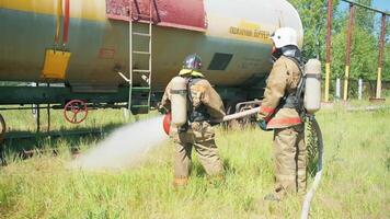 i vigili del fuoco vicino il attrezzatura. clip. Due uomini uso un' enorme Jet di acqua per dai un'occhiata fuoco attrezzatura. video