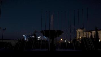 Night city landscape with the beautiful administrative building and a fountain on dark blue sky background. Action. Concept of architecture. video