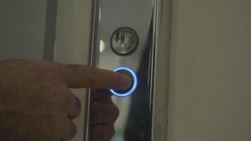 mans hand- drukken lift naar beneden knop. hdr. dichtbij omhoog van mannetje vinger krijgen de lift door voortvarend de zilver metaal knop. video