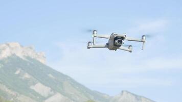 Aerial view of a quadcopter flying above green mountains on morning haze background. Action. Drone filming of natural landscape. video