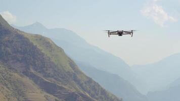 aéreo ver de un quadcopter volador encima verde montañas en Mañana calina antecedentes. acción. zumbido rodaje de natural paisaje. video