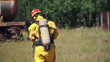 A sign warning of danger. Clip. People performing work in a dangerous area going to a gas mask on the background of a sign warning of danger video