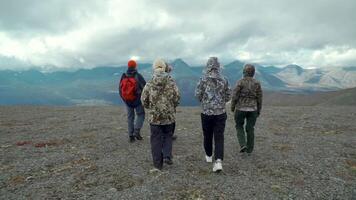 personas mirando a enorme montañas. acortar . un grupo de viajeros en malo clima y Mira a el brumoso grande montañas. video