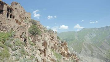 Aerial view of the ancient abandoned destroyed city. Action. Flying above old stone buildings built on the slope of a mountain. video