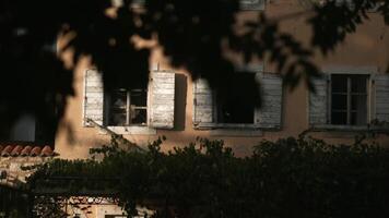 das Aussicht von das Drohne. kreativ. ein schön Backstein architektonisch Gebäude mit Grün Vegetation in der Nähe und öffnen dunkel Fenster video