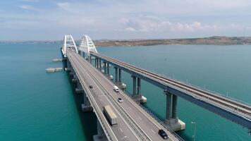 Top view of suspension bridge on water. Shot. Cars are driving on white suspension bridge over blue water. Beautiful seascape with Crimean suspension bridge video