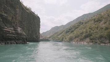 atemberaubend Aussicht von ein Türkis fließend Fluss zwischen Grün Berge. Aktion. Konzept von Reisen und Abenteuer, erkunden wild breit Fluss im ein Schlucht. video