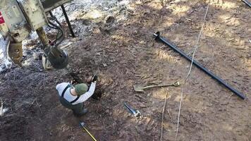 fluxo de trabalho. criativo. uma zangão Visão do uma homem dentro uniforme trabalhando dentro a lama com especial equipamento. video