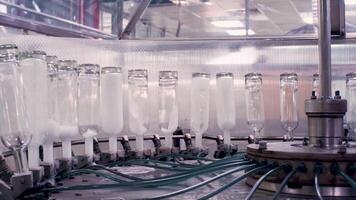 complex voor de productie van glas flessen en drankjes. klem. mechanisch machine in een fabriek met de vervaardiging van glas containers en vloeistoffen. video