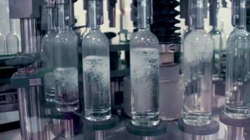 vervaardiging van glas flessen. klem. de productie moment waar de flessen zijn gedekt met deksels voor verder verkoop. video