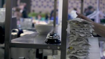 Close up of metal spike with many paper receipts on it. HDR. Interior of a restaurant or a cafe kitchen, waitress hand taking a dish. video