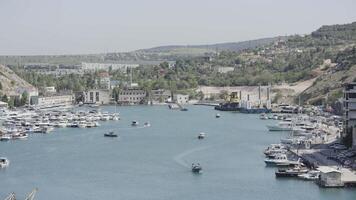 Aerial view of luxury port on a summer day with many yachts. Action. Summer small town with growing trees and mountains. video