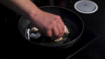 Homemade sauteed chicken breast in a frying pan. Art. Close up of turning chopped chicken breast in flour at the kitchen. video