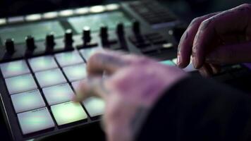 Close up of dj working with the professional drum machine at the night club. Art. Young man tapping fast on the buttons of a beat making machine. video