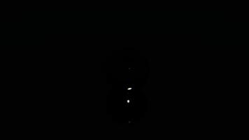 Tiny light particles rising up in the dark. Design. Small flying white dots on a black background, seamless loop, monochrome. video