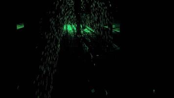 astratto silhouette di maschio gambe a piedi indietro attraverso il buio corridoio con verde raggiante particelle. design. un' uomo supereroe diffusione verde energia. video
