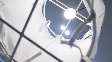 Close up of chandelier hanging on white ceiling background. HDR. White hanging lamp surrounded by white cloth. video