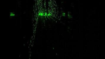 Abstract silhouette of male legs walking through the dark corridor with green glowing particles. Design. A man superhero spreading green energy. video