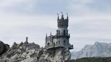 antenne visie van verbazingwekkend zwaluw nest Bij gaspra in Krim, Rusland. actie. sprookje kasteel gebouwd Aan de klif top met groen vallei en blauw lucht Aan de achtergrond. video