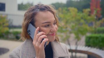 Rusland, Moskou - september 27, 2021. mooi vrouw is pratend Aan telefoon. actie. elegant vrouw is pratend Aan nieuw telefoon. bedrijf vrouw praat Aan nieuw iphone 13 video