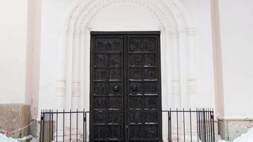 un acero negro pesado puerta y un arco de un tradicional ortodoxo iglesia. concepto. arquitectura, religión, un pared con un negro grande puerta y un pared de un templo. video