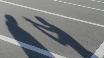 das Silhouetten von zwei jung Männer während wütend Konflikt. hdr. Schatten von streiten freunde mit jeder andere auf das Hintergrund von Parkplatz Asphalt. video