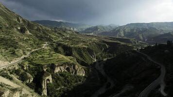 aérien vue de une Stupéfiant vert pente de une Montagne sur une bleu nuageux ciel Contexte. action. sauvage été la nature avec vert herbe couvert rochers. video