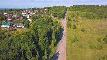 Sommer- Aussicht von ein Drohne auf ein klein Dorf . Clip. ein Sommer- Straße mit Felder und Wälder mit klein Wohn Gebäude. video