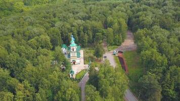 yeux d'oiseau voir. agrafe. une magnifique vert forêt avec une monastère dans le milieu . là sont aussi certains routes et certains des endroits de le ville dans le Contexte. video