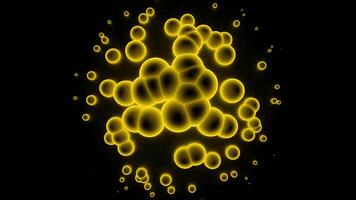 amarillo moléculas parecer a ser en abstracción. diseño. amarillo brillante círculos corriendo en un negro vacío antecedentes video