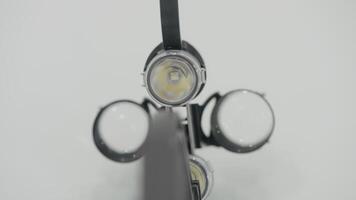 Close-up magnifying glasses for surgery. Action. Professional magnifying glasses with flashlight on white background. Surgical instruments and devices video