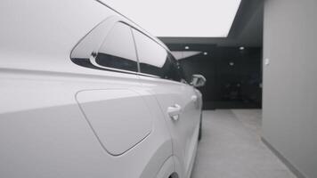 Side view of new white car in store. Action. Beautiful appearance of new white car in sales salon. Stylish Long car for sale video