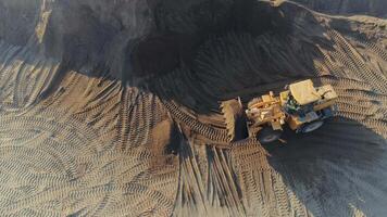 Aerial top view of the machines at work at the construction site. Scene. Bulldozer and truck working with sand. video