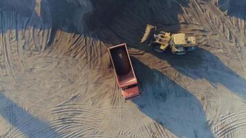 aereo superiore Visualizza di il macchine a opera a il costruzione luogo. scena. bulldozer e camion Lavorando con sabbia. video