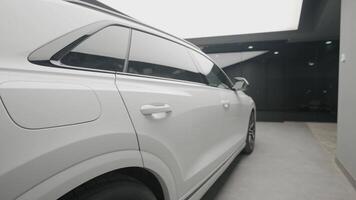Side view of new white car in store. Action. Beautiful appearance of new white car in sales salon. Stylish Long car for sale video