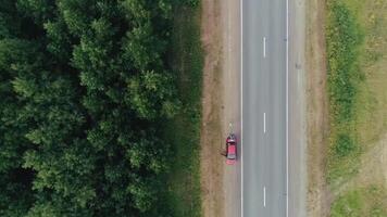 Top view of dividing line of forests and fields. Scene. Cars are driving on country highway with forest strip. Highway divides forest zone and field video