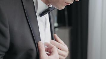 Close up of a man dressed in black and white suit with a bow tie. Action. Details of a worried male groom before the wedding ceremony. video