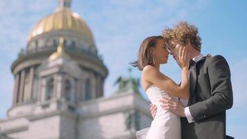 mariage photo tirer. action. une couple pose suivant à st. Isaac c'est cathédrale , une Jeune homme avec longue frisé cheveux et le sien la mariée avec nu épaules et longue des boucles d'oreilles video