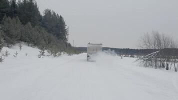 antenn se av vinter- landskap med de snö täckt fält och träd i landsbygden område. klämma. vit väg med en körning lastbil. video