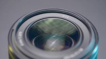 Close up of a new camera lens on blurred grey background. Action. Details of professional photographer equipment. video